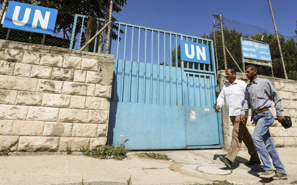 Người Palestine đi ngang qua cổng một trường học do UNRWA điều hành ở Nablus tại Tây Ngạn, ngày 13/08/2018. (Ảnh: Abed Omar Qusini/Reuters)