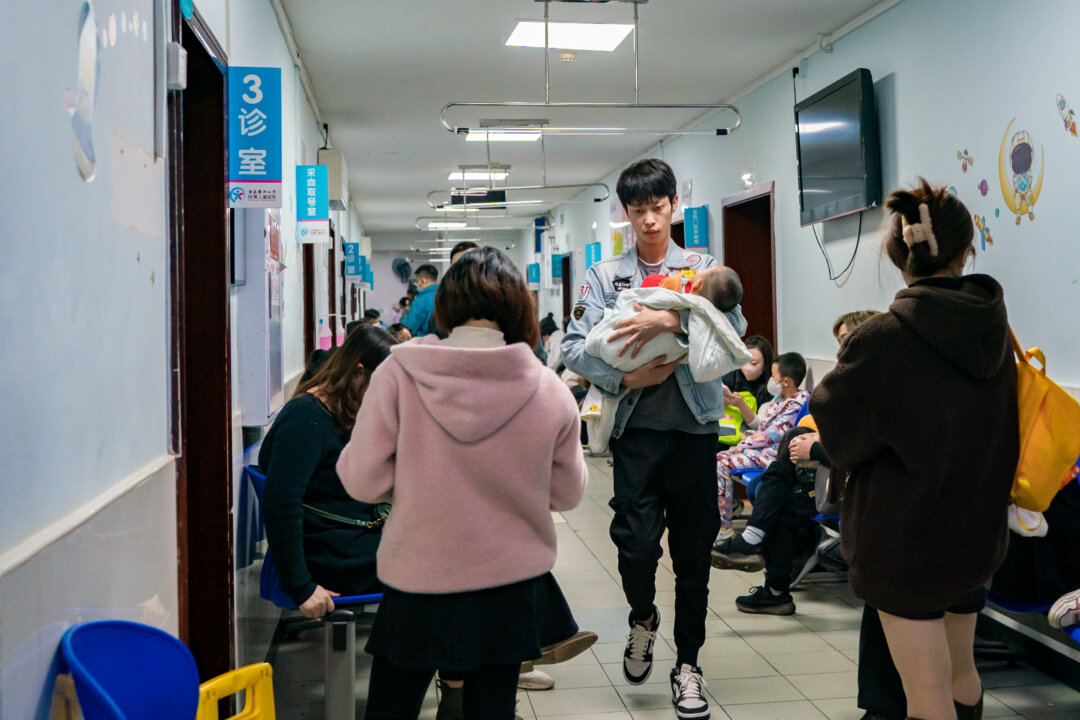 Các bậc cha mẹ có con mắc bệnh hô hấp đang xếp hàng tại một bệnh viện nhi ở Trùng Khánh, Trung Quốc, hôm 23/11/2023. (Ảnh: CFOTO/Future Publishing qua Getty Images)