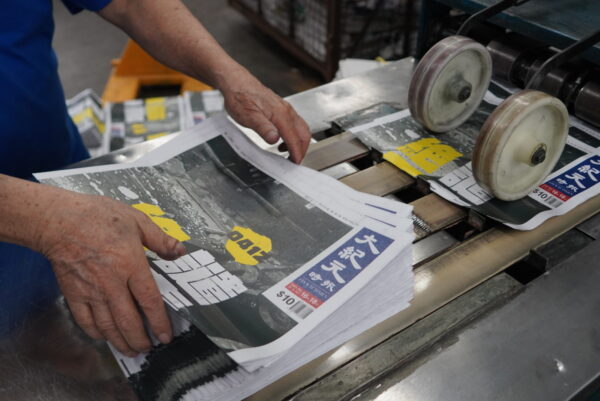 Các tờ báo của The Epoch Times phiên bản Hồng Kông ra khỏi máy in khi hãng truyền thông này tiếp tục in báo sau khi xưởng in của họ bị tấn công vào ngày 12/04/2021. (Ảnh: The Epoch Times)