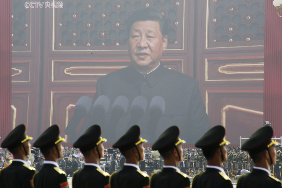 Các binh sĩ của Quân Giải phóng Nhân dân đứng trước một màn hình lớn khi nhà lãnh đạo Trung Quốc Tập Cận Bình đọc diễn văn tại cuộc duyệt binh kỷ niệm 70 năm thành lập chế độ ở Bắc Kinh vào ngày 01/10/2019. (Ảnh: Jason Lee/Reuters)