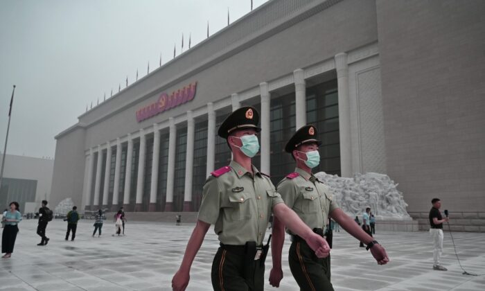 Hai công an Trung Quốc đi tuần tra bên ngoài Bảo tàng Đảng Cộng sản Trung Quốc mới xây ở Bắc Kinh vào ngày 25/06/2021. (Ảnh: Kevin Frayer/Getty Images)