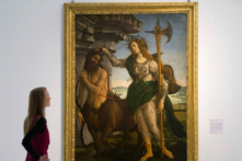 Một nhân viên tạo dáng chụp ảnh cùng tác phẩm “Pallas and Centaur” (Pallas và Nhân Mã) của nghệ sĩ người Ý Sandro Botticelli, được sáng tác vào khoảng năm 1482. (Ảnh: Justin Tallis/AFP/Getty Images)