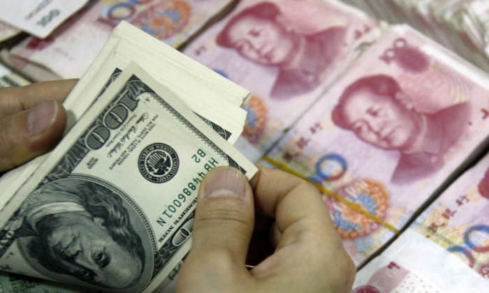 Tiền USD đang được đếm bên cạnh các tập tiền giấy 100 nhân dân tệ (RMB) tại một ngân hàng ở Hoài Bắc, tỉnh An Huy, miền đông Trung Quốc, ngày 24/09/2013. (Ảnh: STR/AFP qua Getty Images)