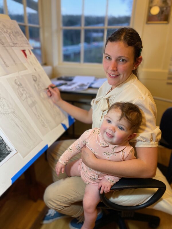 Họa sĩ vẽ tranh minh họa Bernadette Carstensen cùng bé Fiona, một trong năm người con nhỏ của cô tại xưởng vẽ ở San Francisco, năm 2021. Một trong các con cô đã được đưa vào các bức tranh minh họa thiêng liêng của cô. (Ảnh: Đăng dưới sự cho phép của Bernadette Carstensen)