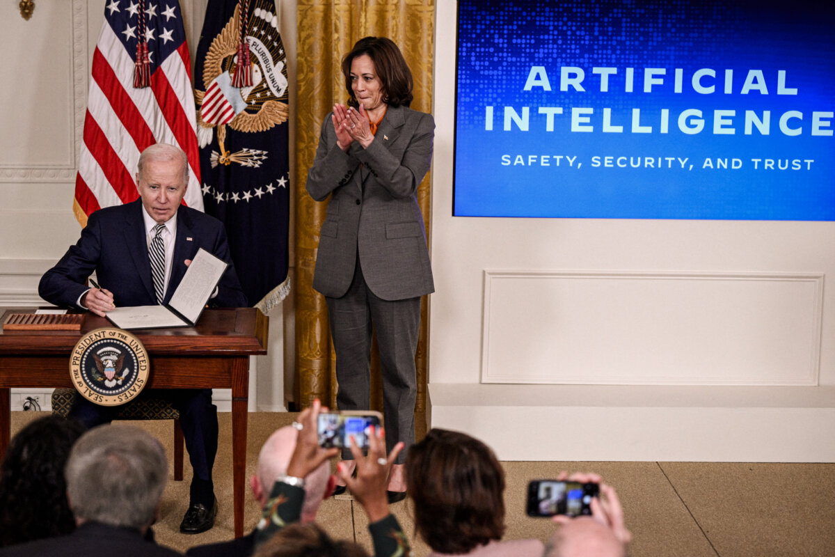 Phó Tổng thống Kamala Harris tán thưởng khi Tổng thống Joe Biden ký sắc lệnh sau khi đưa ra nhận xét về việc thúc đẩy phát triển và sử dụng trí tuệ nhân tạo một cách an toàn, bảo mật, và đáng tin cậy, tại Phòng phía Đông của Tòa Bạch Ốc ở Hoa Thịnh Đốn, vào ngày 30/10/2023. (Ảnh: Brendan Smialowski / AFP qua Getty Images)