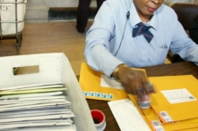 Trong bức ảnh tư liệu này, một nhân viên bưu điện đang dán tem phong bì cho IRS. (Ảnh: Monika Graff/Getty Images)