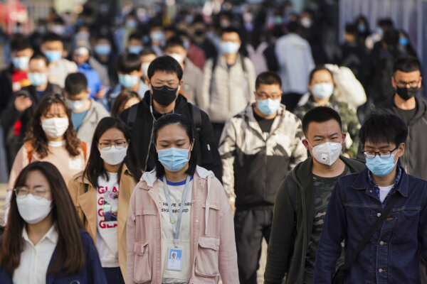 Những người đi làm đeo khẩu trang bảo vệ khi rời khỏi ga tàu điện ngầm trong giờ cao điểm hôm 13/04/2020, tại Bắc Kinh, Trung Quốc. Theo thống kê của Tổ chức Y tế Thế giới, tính đến hôm nay, số trường hợp được xác nhận nhiễm COVID-19 đã vượt quá 1.69 triệu, trong đó có 106,138 trường hợp tử vong. (Ảnh: Lintao Zhang/Getty Images)