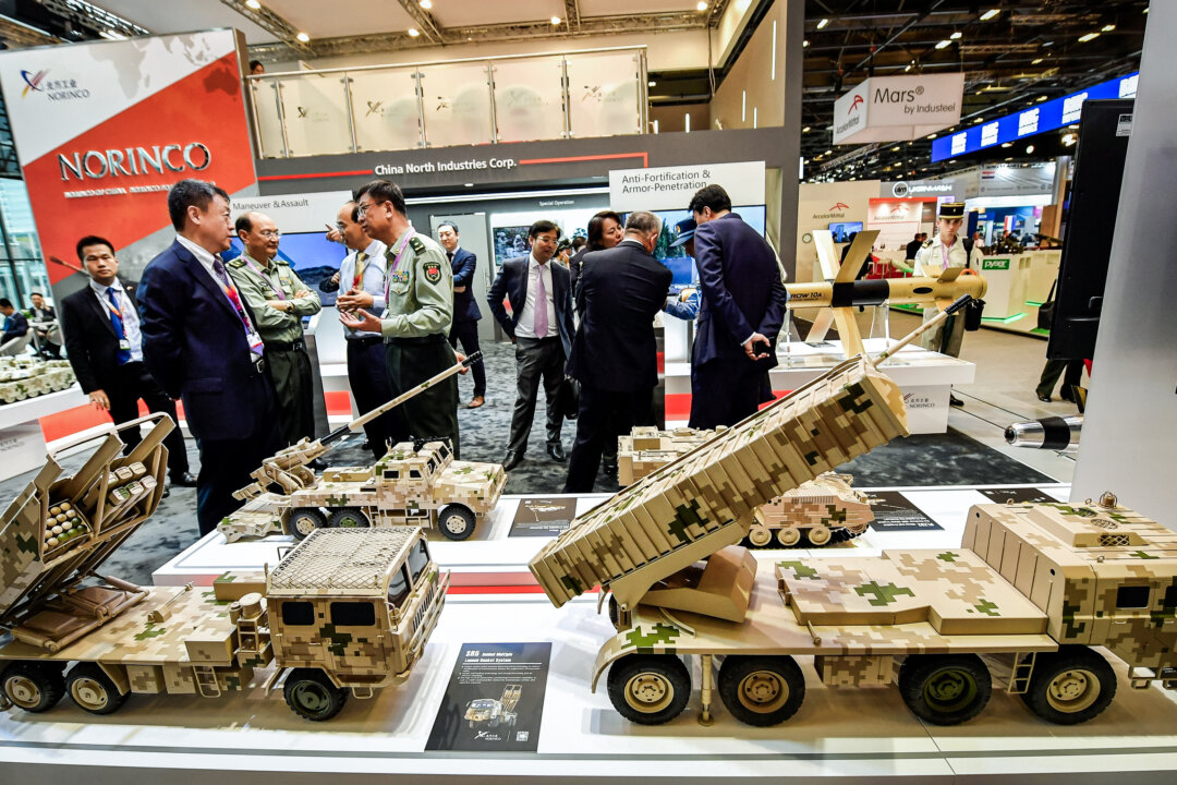 Những người khách nói chuyện với nhân viên quân sự bên cạnh các mẫu xe quân sự do một công ty Trung Quốc sản xuất tại một triển lãm quốc tế ở Villepinte, gần Paris vào ngày 11/06/2018. (Ảnh: Gerard Julien/AFP qua Getty Images)