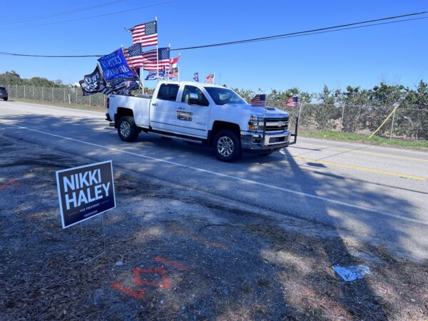 Một chiếc xe bán tải treo cờ bao gồm cờ ủng hộ cựu TT Donald Trump đi ngang qua địa điểm diễn ra sự kiện tranh cử của bà Nikki Haley ở Columbia, South Carolina, hôm 01/02/2024. (Ảnh: Lawrence Wilson/The Epoch Times)