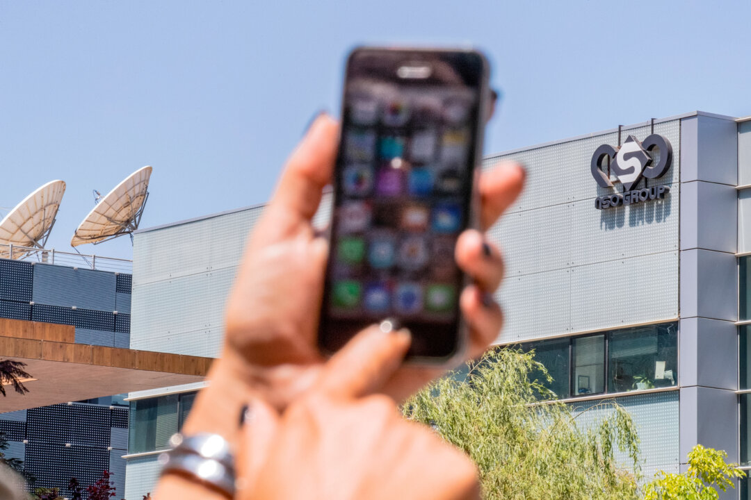 Một phụ nữ Israel sử dụng iPhone của mình trước tòa nhà nơi công ty NSO Group của Israel tọa lạc ở Herzliya, gần Tel Aviv, hôm 28/08/2016. (Ảnh: Jack Guez/AFP qua Getty Images)