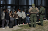 Các nhân viên Tuần tra Biên giới Hoa Kỳ canh giữ những người nhập cư bất hợp pháp vượt biên vào Công viên Shelby khi họ chờ được đưa đi giải quyết ở Eagle Pass, Texas, hôm 04/02/2024. (Ảnh: Michael Gonzalez/Getty Images)
