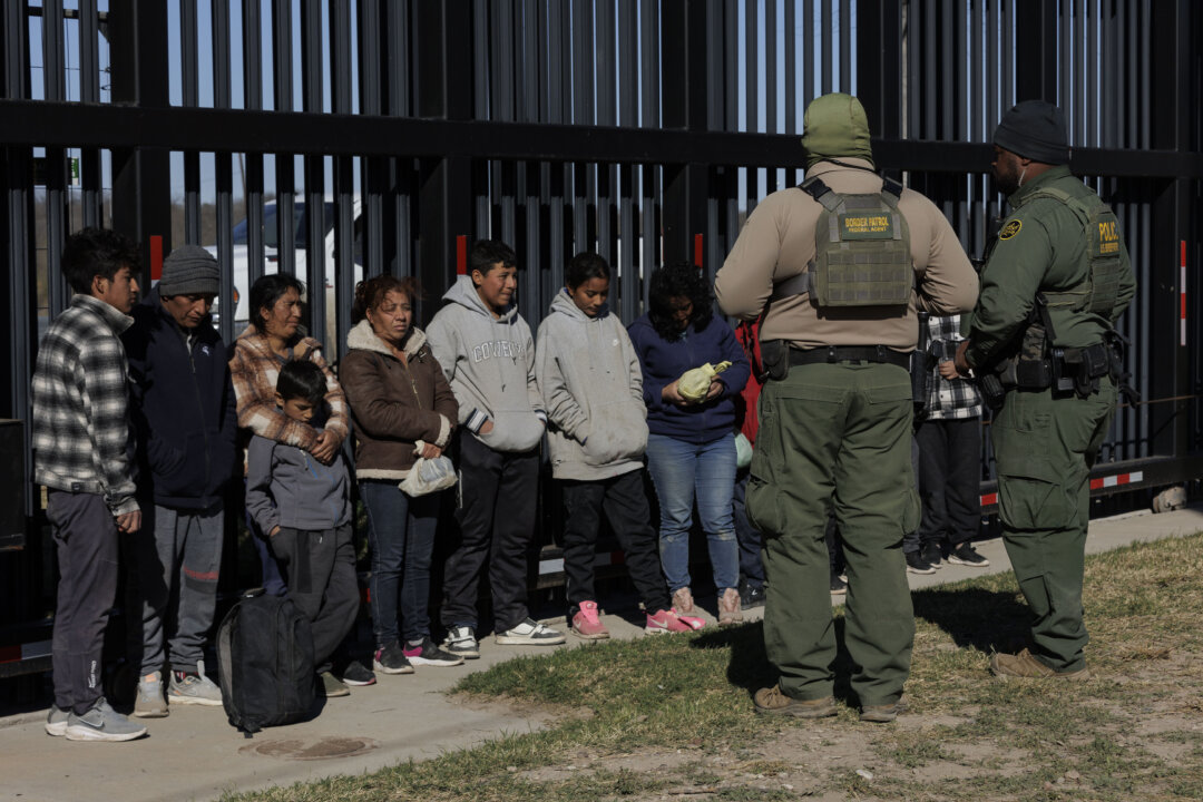 Các nhân viên Tuần tra Biên giới Hoa Kỳ canh giữ những người nhập cư bất hợp pháp vượt biên vào Công viên Shelby khi họ chờ được đưa đi giải quyết ở Eagle Pass, Texas, hôm 04/02/2024. (Ảnh: Michael Gonzalez/Getty Images)