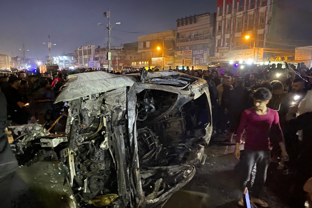 Người Iraq tập trung tại địa điểm một chiếc xe bị đốt cháy do cuộc tấn công bằng phi cơ không người lái của Hoa Kỳ ở phía đông Baghdad, Iraq, hôm thứ Tư, ngày 07/02/2024. (Ảnh: AP Photo/Hadi Mizban)