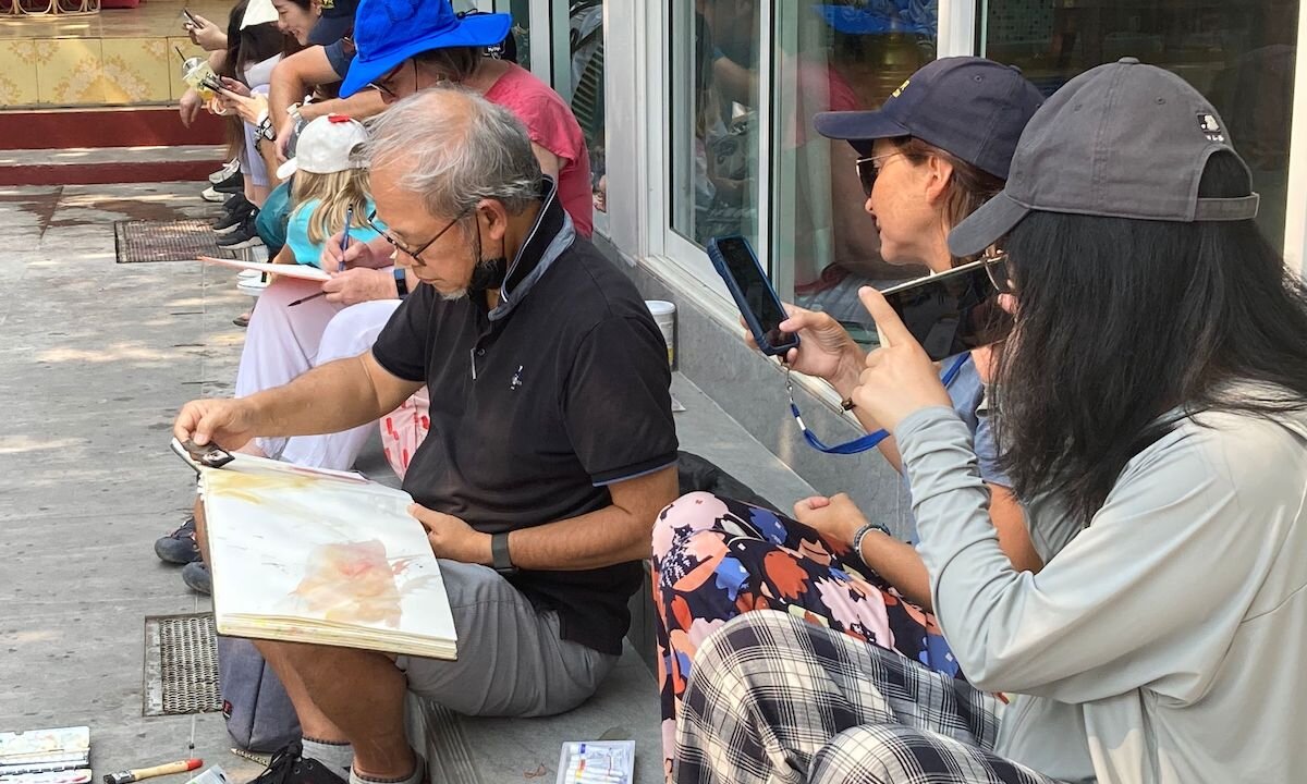 Ông Richie Cheung và những người bạn đang ký họa trên đường phố Thái Lan, thu hút người qua đường. (Ảnh: Được đăng dưới sự cho phép của ông Richie Cheung)