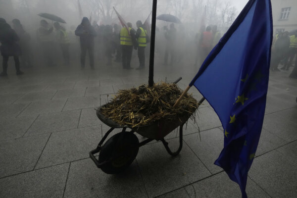 Nông dân Ba Lan, tức giận với chính sách ruộng đất của EU và hàng nhập cảng giá rẻ của Ukraine mà họ cho rằng đang cắt giảm sinh kế của mình, đậu một chiếc xe đẩy tay chở đầy phân với lá cờ EU cắm phía trên, để biểu tình trước văn phòng thống đốc khu vực, ở Poznan, miền tây Ba Lan, hôm thứ Sáu ngày 09/02/2024. (Ảnh: Czarek Sokolowski /AP Photo)
