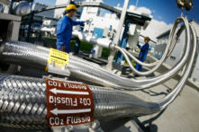 Hai nhân viên làm việc trên các đường ống dẫn CO2 lỏng tại nhà máy điện Schwarze Pumpe ở Brandenburg, Đức, vào ngày 08/09/2008. (Ảnh: Michael Urban/DDP/AFP qua Getty Images)