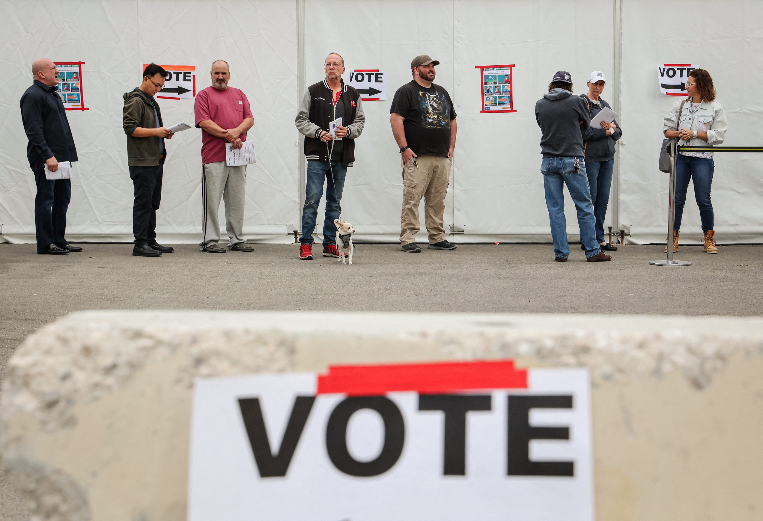 Các tấm biển vận động tranh cử được trưng bày gần cử tri đang xếp hàng chờ tại một điểm bỏ phiếu vào Ngày Bầu Cử ở Las Vegas, vào ngày 08/11/2022. (Ảnh: Ronda Churchill/AFP qua Getty Images)
