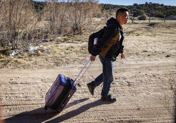 Một người Trung Quốc nhập cư bất hợp pháp di chuyển đến một khe mở ở bức tường biên giới Hoa Kỳ ở Jacumba, California, hôm 06/12/2023. (Ảnh: John Fredricks/The Epoch Times)