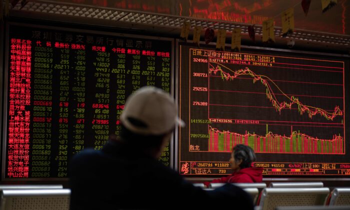 Các nhà đầu tư xem diễn biến giá cổ phiếu trên màn hình hiển thị giá cổ phiếu tại một công ty chứng khoán ở Bắc Kinh, Trung Quốc hôm 11/10/2018. (Ảnh: Nicolas Asfouri/AFP qua Getty Images)
