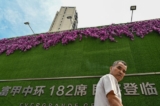 Một người đàn ông đi ngang qua một tòa nhà chung cư do Evergrande phát triển ở Thượng Hải hôm 24/09/2021. (Ảnh: Hector Retamal/AFP qua Getty Images)