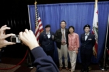 Những công dân Hoa Kỳ mới nhập tịch chụp ảnh với các thành viên của đội cận vệ da màu Junior ROTC của Lực lượng Không quân Hoa Kỳ sau khi tuyên thệ trở thành công dân Hoa Kỳ, trong buổi lễ nhập tịch ở San Francisco, vào ngày 23/05/2006. (Ảnh: Justin Sullivan/Getty Images)
