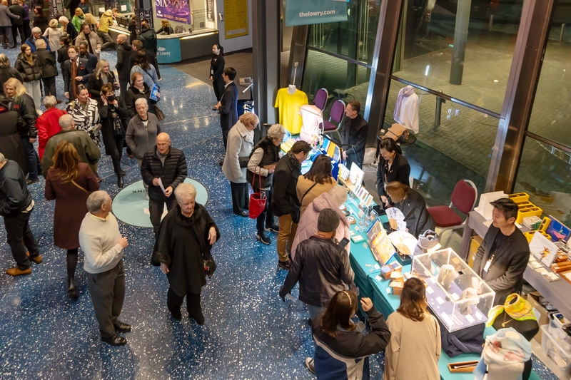 Khán giả mua các sản phẩm của Shen Yun tại Trung tâm Nghệ thuật The Lowry Salford ở Anh Quốc, tối hôm 23/02. (Ảnh: La Nguyên/Epoch Times)