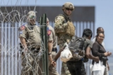 Một người lính Vệ binh Quốc gia Texas quan sát một người nhập cư bất hợp pháp bước vào một trại tạm ở El Paso, Texas, vào ngày 11/05/2023. (Ảnh: John Moore/Getty Images)