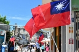 Khách du lịch đi dạo dưới bóng cờ Đài Loan tung bay trên một tuyến phố đi bộ tại quần đảo Kim Môn, Đài Loan, vào ngày 11/08/2022. (Ảnh: Sam Yeh/AFP qua Getty Images)