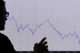 Một người đàn ông nhìn vào biểu đồ thể hiện sự sụt giảm trong 12 tháng của chỉ số cổ phiếu FTSE 100, tại London, hôm 07/10/2008. (Ảnh: Peter Macdiarmid/Getty Images)