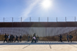 Những người nhập cư bất hợp pháp, trước đó đã đi qua một khe hở trên bức tường biên giới Hoa Kỳ, đang chờ nhân viên Tuần tra Biên giới làm thủ tục giải quyết ở Jacumba, California, vào ngày 07/12/2023. (Ảnh: John Fredricks/The Epoch Times)