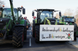 Một máy kéo treo biểu ngữ có nội dung “Người khác thì các vị đi nuôi dưỡng, còn chúng tôi thì các vị muốn đuổi đi,” trong bối cảnh nông dân Đức biểu tình phản đối việc cắt giảm trợ cấp thuế phương tiện của cái gọi là chính phủ liên minh Đèn giao thông của Đức ở Berlin, Đức, hôm 08/01/2024. (Ảnh: Nadja Wohlleben/Reuters)