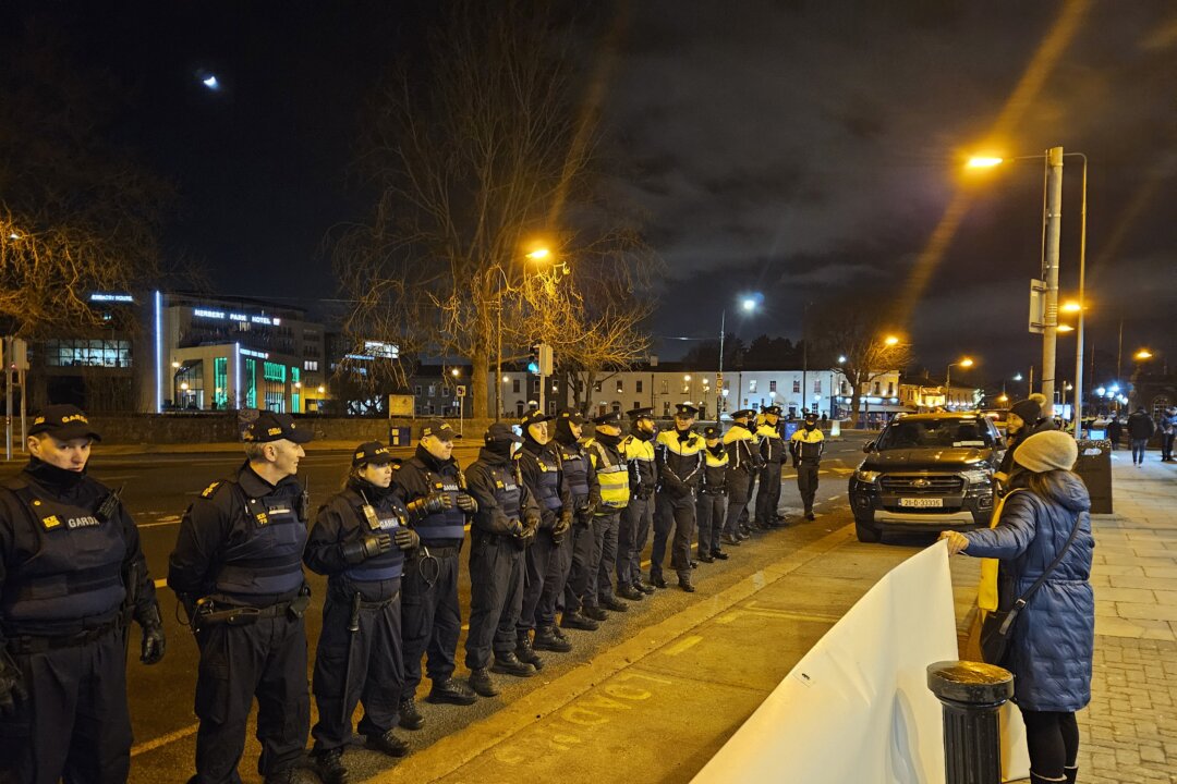 Một nhóm cảnh sát đối mặt với các học viên Pháp Luân Công đang giương biểu ngữ gần một khách sạn nơi phái đoàn Trung Quốc, do Thủ tướng Lý Cường dẫn đầu, đang lưu trú tại Dublin, Ireland, hôm 16/01/2024. (Ảnh: Hiệp hội Pháp Luân Đại Pháp Ireland)