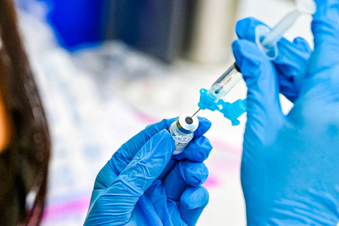 Một nhân viên chăm sóc sức khỏe đang rút vaccine COVID-19 của Pfizer vào bơm chích thuốc. (Ảnh: Robyn Beck/AFP qua Getty Images)