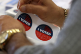 Một nhân viên bầu cử chuẩn bị phát các nhãn dán “Tôi đã bỏ phiếu” ở Burbank, California, hôm 05/03/2024. (Ảnh: Justin Sullivan/Getty Images)