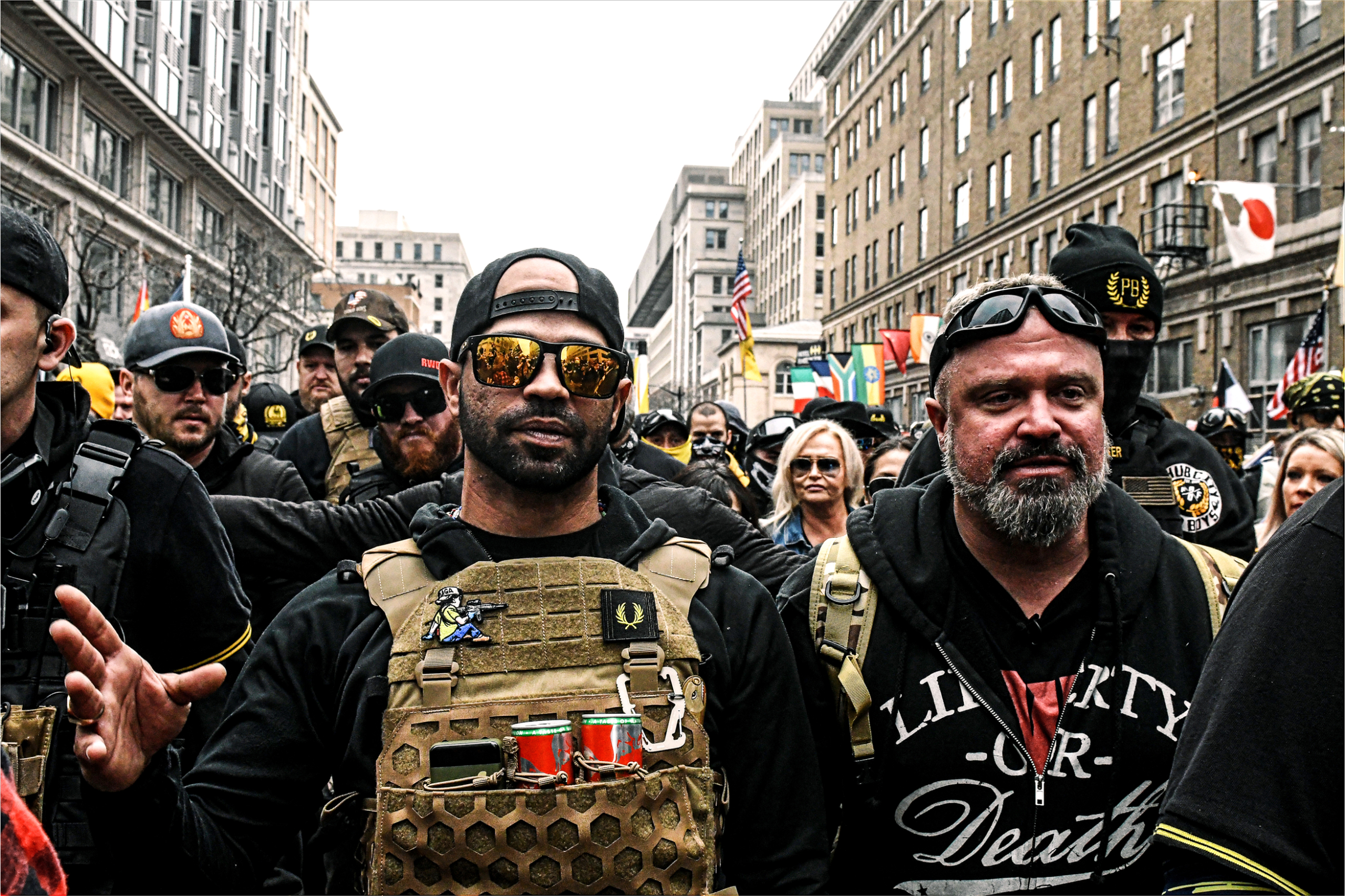 (Trên) Người sáng lập Oath Keepers Elmer Stewart Rhodes III xuất hiện trên màn hình trong phiên điều trần về cuộc điều tra vụ ngày 06/01 tại Hoa Thịnh Đốn, vào ngày 12/07/2022. (Dưới) Các thành viên của Proud Boys biểu tình phản đối các kết quả cuộc bầu cử tổng thống năm 2020, tại Hoa Thịnh Đốn, vào ngày 12/12/2020. (Ảnh: Anna Moneymaker, Stephanie Keith/Getty Images)