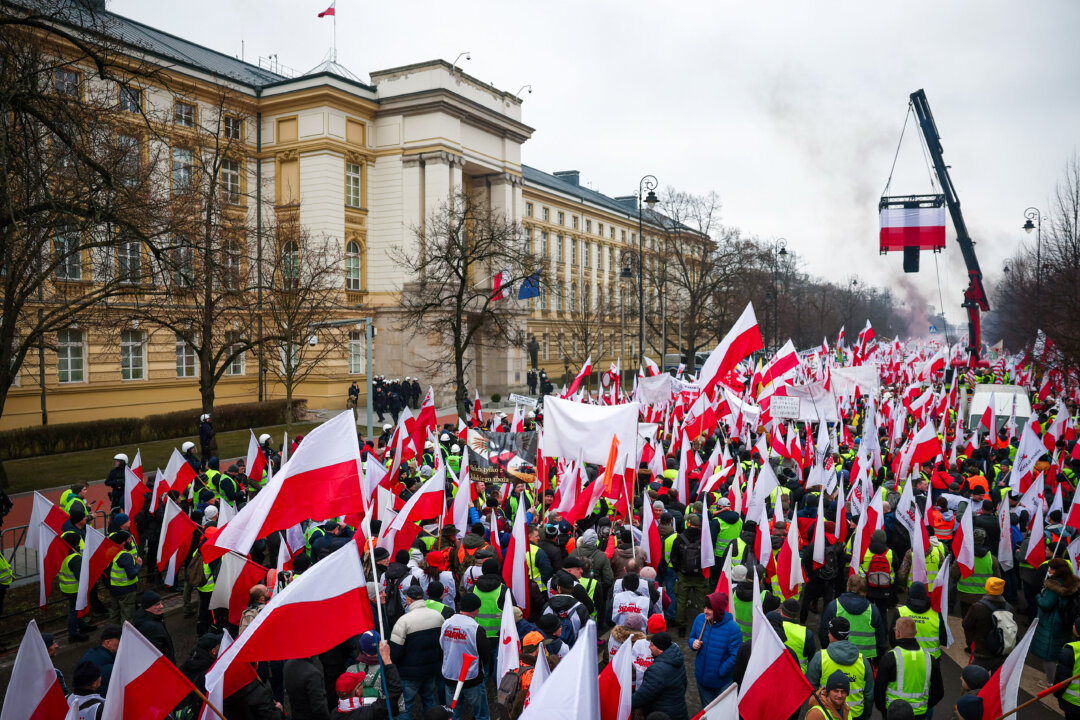 Mọi người mang theo cờ và biểu ngữ Ba Lan, trong bối cảnh nông dân đang biểu tình bên ngoài văn phòng Thủ tướng Ba Lan Donald Tusk để phản đối Thỏa thuận Xanh của Liên minh  u Châu và việc nhập cảng các sản phẩm nông nghiệp của Ukraine, tại Warsaw, Ba Lan, hôm 06/03/2024. (Ảnh: Kacper Pempel/Reuters)