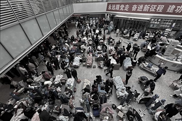 Bệnh nhân được người thân và nhân viên y tế chăm sóc trên những chiếc giường được đặt ở khu vực thông tầng của một bệnh viện đông đúc ở Thượng Hải, Trung Quốc, vào ngày 13/01/2023. (Ảnh: Kevin Frayer/Getty Images)