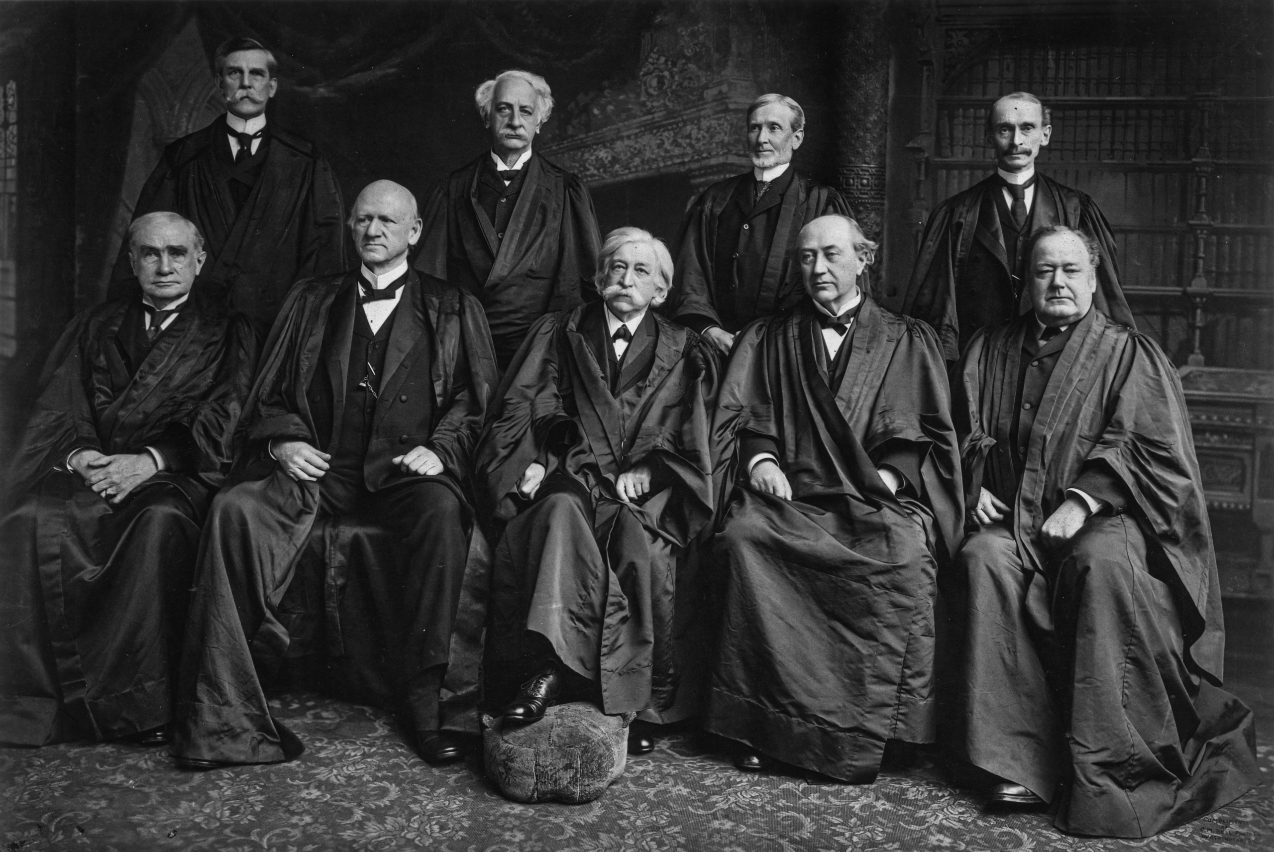 Các thành viên của Tối cao Pháp viện năm 1904: Thẩm phán Oliver Wendell Holmes, Thẩm phán Rufus W. Peckham, Thẩm phán Joseph McKenna, Thẩm phán William Rufus Day, Thẩm phán Henry Billings Brown, Thẩm phán John Marshall Harlan, Chánh án Melville Weston Fuller, Thẩm phán David Josiah Brewer, và Thẩm phán Edward Douglass White (Ảnh: MPI/Getty Images)