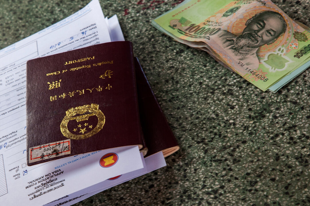 Một cuốn sổ thông hành Trung Quốc và một số tờ tiền Việt Nam bị bỏ lại trên bàn làm việc của văn phòng quan thuế, nơi nộp đơn yêu cầu cung cấp thị thực nhập cảnh Campuchia tại cảng nhập cảnh Bavet, Campuchia vào ngày 16/05/2014. (Ảnh: Omar Havana/Getty Images)