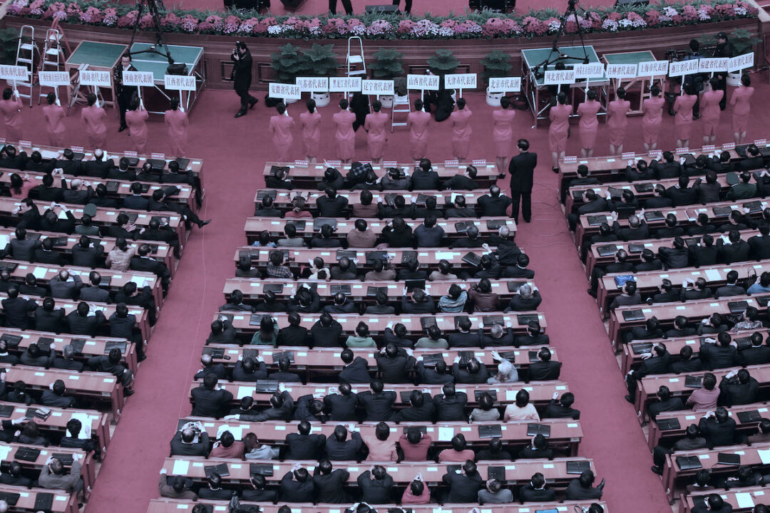 Nhân viên tiếp đón đang chờ đợi để hướng dẫn đại biểu vào các nhóm nhỏ thảo luận về dự thảo luật chống ly khai trong phiên họp toàn thể thứ hai của Đại hội Đại biểu Nhân dân Toàn quốc, hay Quốc hội, vào ngày 08/03/2005 tại Bắc Kinh, Trung Quốc. (Ảnh: Cancan Chu/Getty Images)