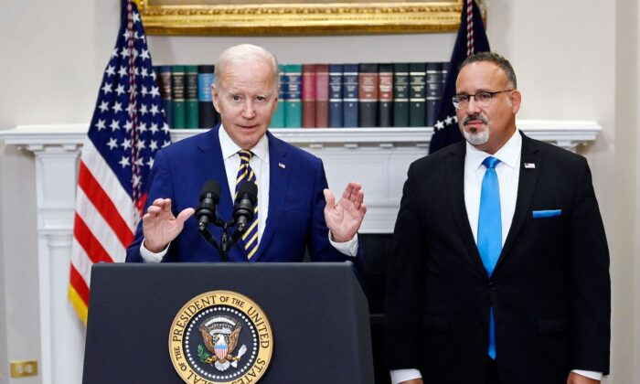 Tổng thống Joe Biden tuyên bố xóa khoản nợ sinh viên cùng với Bộ trưởng Giáo dục Miguel Cardona (phải) tại Toà Bạch Ốc vào ngày 24/08/2022. (Ảnh: Olivier Douliery/AFP qua Getty Images)