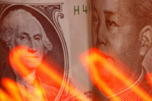 Trong hình minh họa chụp ngày 10/02/2020 này, đồng nhân dân tệ của Trung Quốc và đồng USD hiển thị đằng sau một biểu đồ chứng khoán được chiếu sáng. (Ảnh: Dado Ruvic/Illustration/ Reuters)