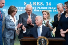Tổng thống Joe Biden trao cây bút cho bà Nancy Pelosi của Hạ viện (thứ hai từ trái sang), cùng với các thành viên khác của Hạ viện, sau khi ký dự luật giải quyết vấn đề phát thải khí nhà kính, tại Tòa nhà Văn phòng Điều hành Eisenhower, ở Hoa Thịnh Đốn hôm 30/06/2021. (Ảnh: Saul Loeb/AFP/Getty Images)