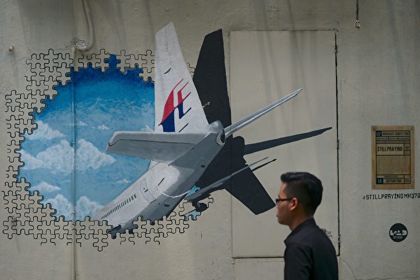 Chiếc phi cơ chở khách Boeing 777 MH370 của hãng hàng không Malaysia Airlines đã biến mất khỏi màn hình radar khi đang trên đường từ Kuala Lumpur đến Bắc Kinh vào sáng sớm ngày 08/03/2014. Cho đến nay cuộc tìm kiếm vẫn chưa có kết quả, khiến nó trở thành một trong những bí ẩn lớn nhất trong lịch sử ngành công nghiệp hàng không. Ảnh chụp một người đàn ông đi ngang qua bức tranh tường về chuyến bay MH370 của Malaysia Airlines ở ngoại ô Kuala Lumpur. (Ảnh: Mohd Rasfan/AFP/Getty Images)