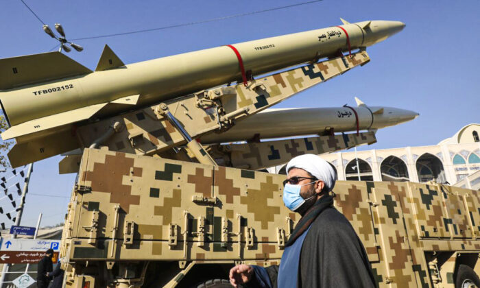 Một giáo sĩ đi ngang qua phi đạn Zolfaghar (ở trên) và phi đạn Dezful ở Tehran, Iran, vào ngày 07/01/2022. (Ảnh: Vahid Salemi/AP Photo)