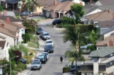 Một người đàn ông đi bộ dọc theo một con phố trong một khu dân cư có các ngôi nhà loại single-family ở Los Angeles, California, ngày 30/07/2021. (Ảnh: Frederic J. Brown/AFP qua Getty Images)