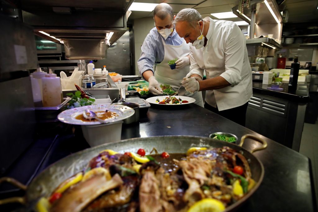 Đầu bếp ba sao người Pháp Christian Le Squer (phải) và đầu bếp một sao Alan Taudon (trái) nấu ăn cho nhân viên của một bệnh viện ở Paris trong bếp của nhà hàng “Le Cinq” tại khách sạn Four Season George V Palace ở Paris, vào ngày 11/04/2020. (Ảnh: Thomas Coex/AFP qua Getty Images)