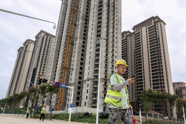 Một công nhân đi ngang qua một khu nhà chung cư đang đang trong quá trình thi công của nhà phát triển địa ốc Trung Quốc Evergrande ở Vũ Hán, tỉnh Hồ Bắc, miền trung Trung Quốc, hôm 28/09/2023. (Ảnh: STR/AFP qua Getty Images)