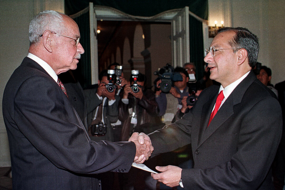 Tổng thống Bolivia Hugo Banzer bắt tay ông Victor Manuel Rocha (phải), Đại sứ Hoa Kỳ tại Bolivia, trong buổi lễ tại Cung điện Chính phủ ở La Paz, Bolivia, vào ngày 03/08/2000. (Ảnh: Reuters)