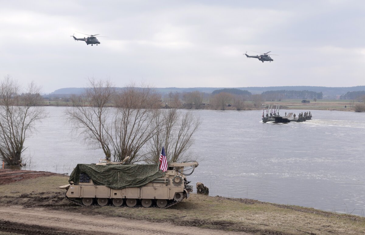 Trực thăng của quân đội Ba Lan bay qua sông Vistula khi một xe chiến đấu của Hoa Kỳ đi qua trong cuộc tập trận quân sự Dragon 24 của NATO gần Gniew, Ba Lan, hôm 04/03/2024. (Ảnh: Sean Gallup/Getty Images)